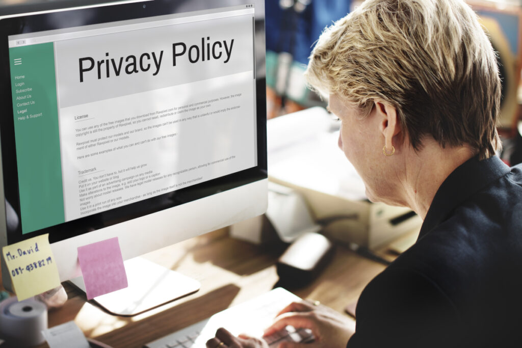 Osoba czyta dokument „Privacy Policy” na ekranie komputera, symbol polityki prywatności i ochrony danych osobowych na stronie internetowej