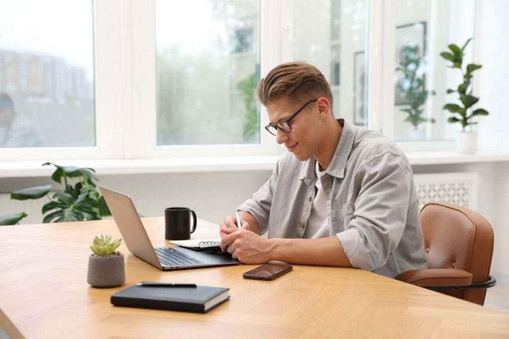 Profesjonalny copywriter piszący teksty na stronę internetową przy biurku z laptopem.