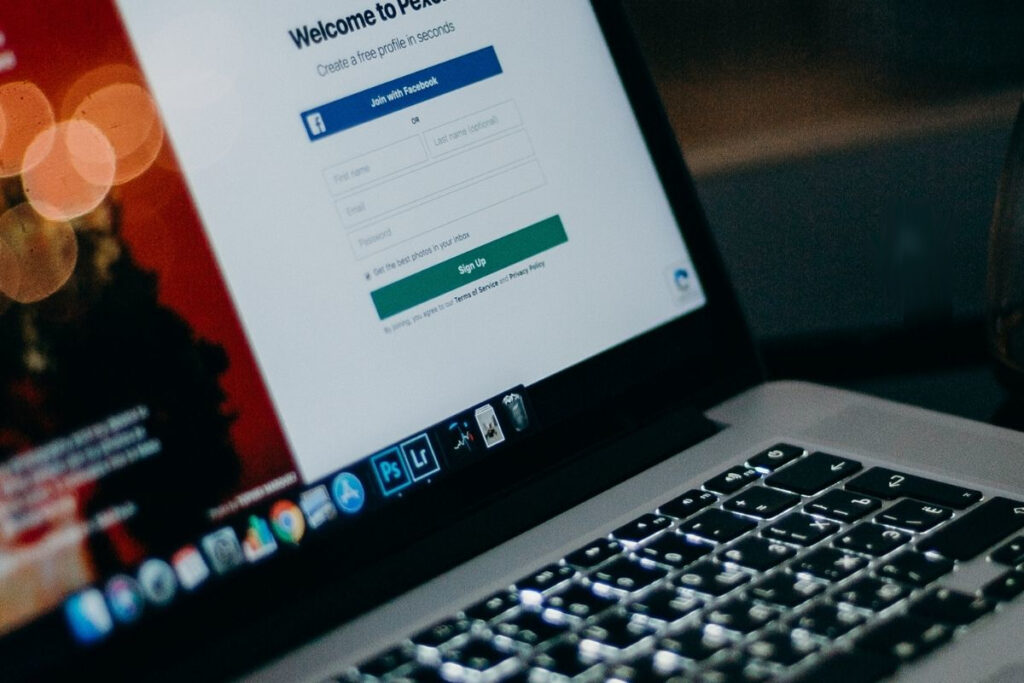 Ekran laptopa pokazujący stronę logowania z opcją dołączenia przez Facebooka.