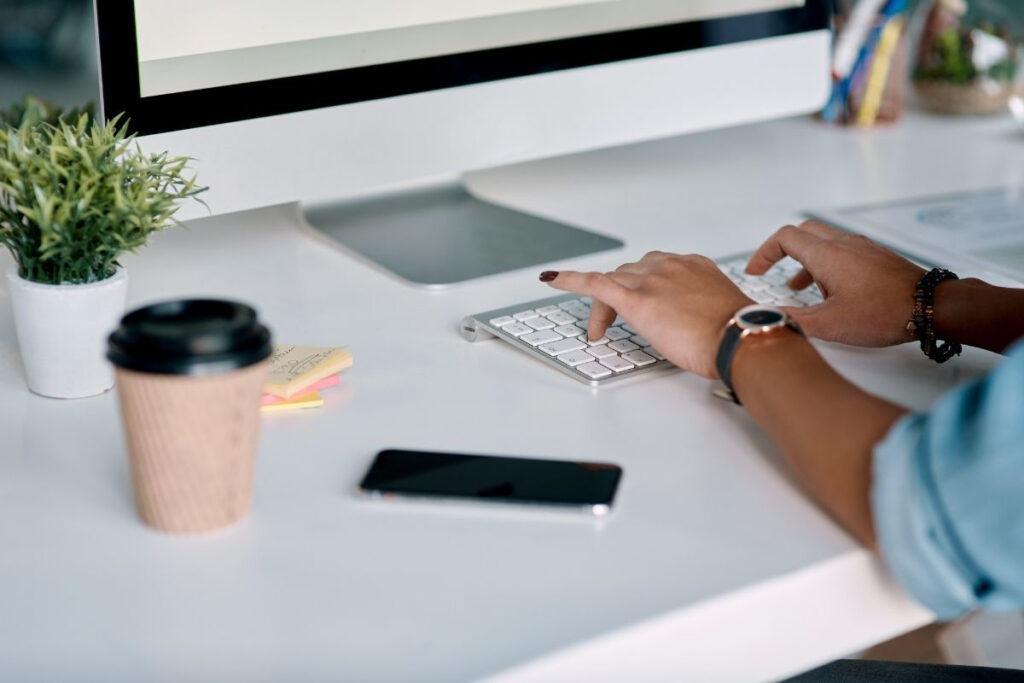 Profesjonalny copywriting dla biznesu w praktyce. Kobieta tworzy skuteczne teksty na stronę WWW, pisząc na klawiaturze komputera.