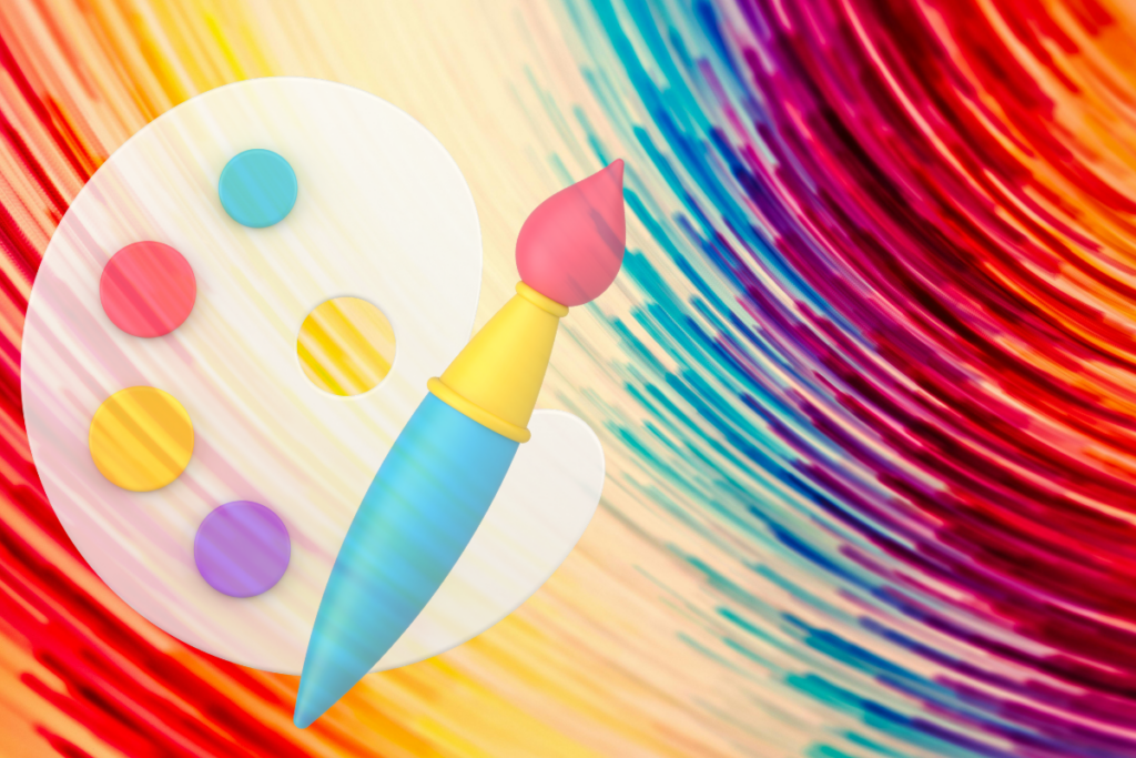 Paleta malarska z pędzlem symbolizująca kreatywne podejście do grafiki reklamowej.